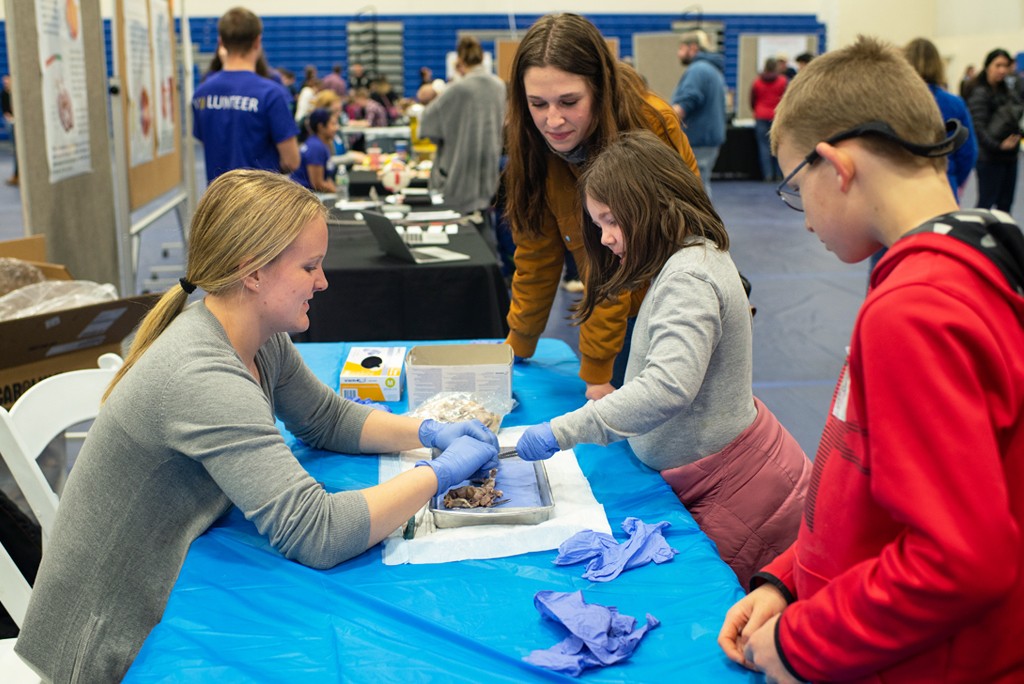 A 51Ʒstudent works with kids during the CEN Brain Fair event